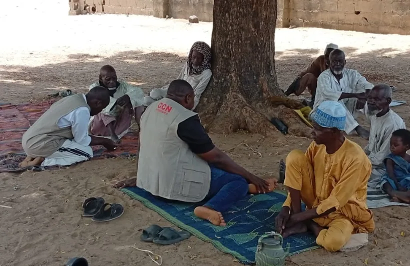 A small group seated beneath a tree