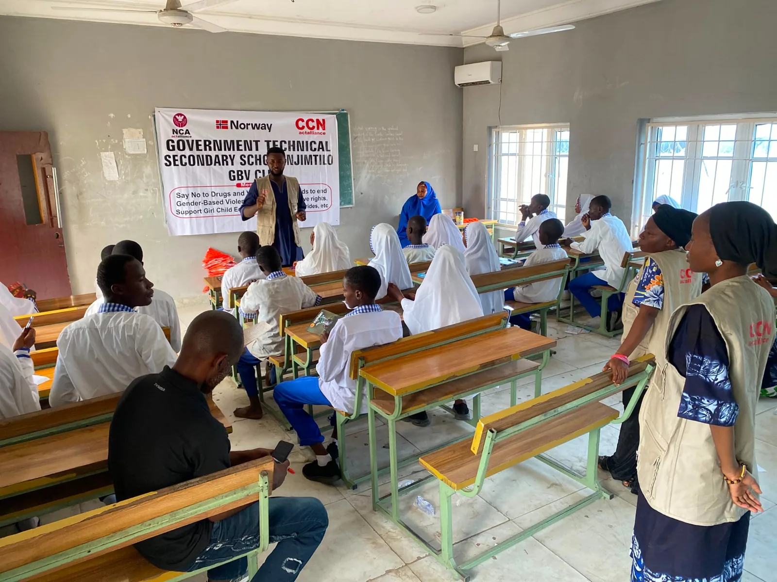 A facilitator speaking to students in a classroom