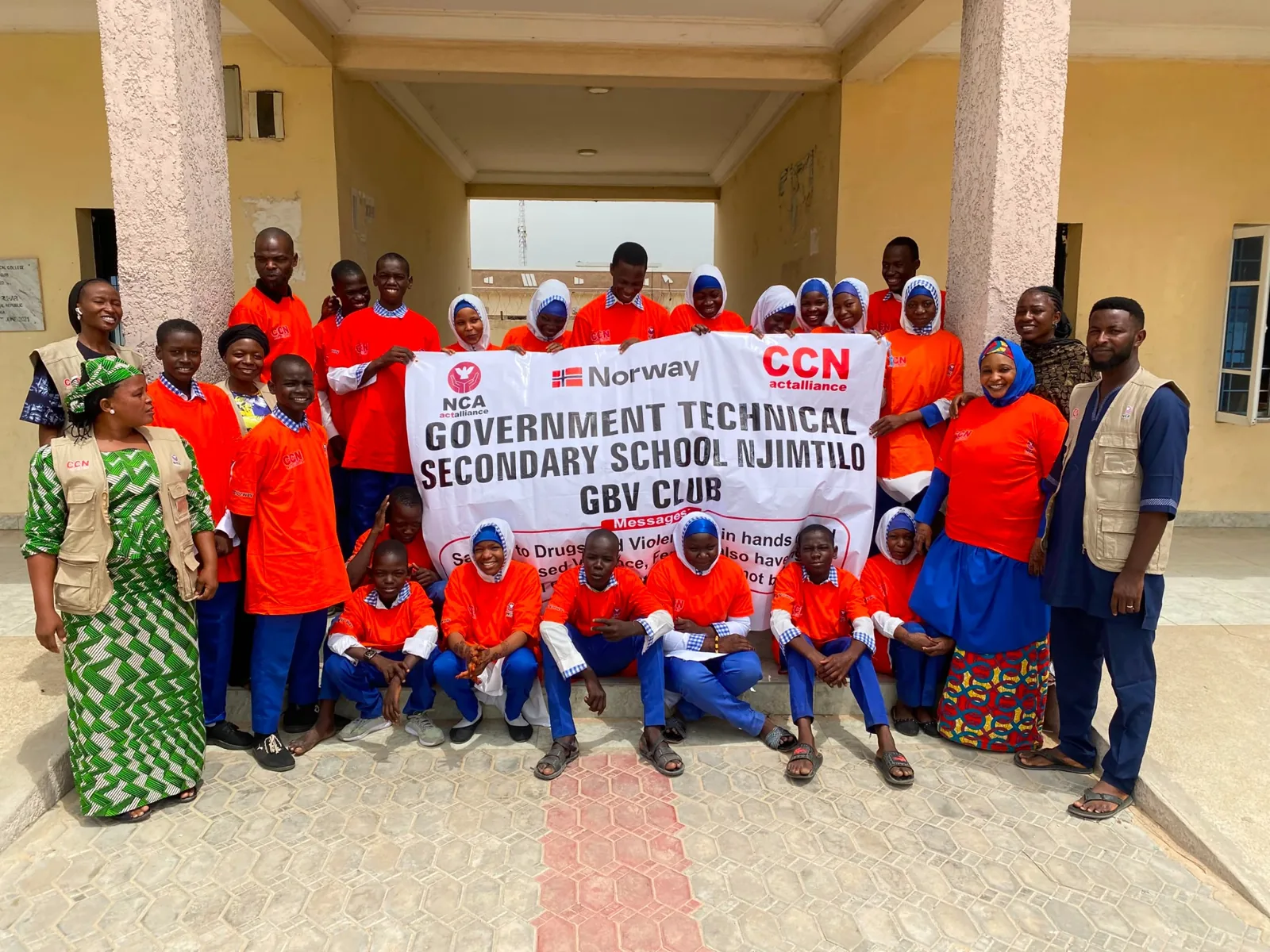 A group holding a school GBV club banner