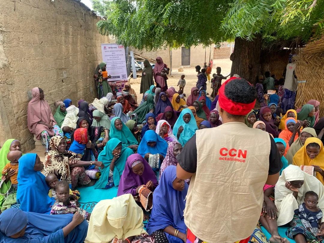 A facilitator addressing an outdoor gathering