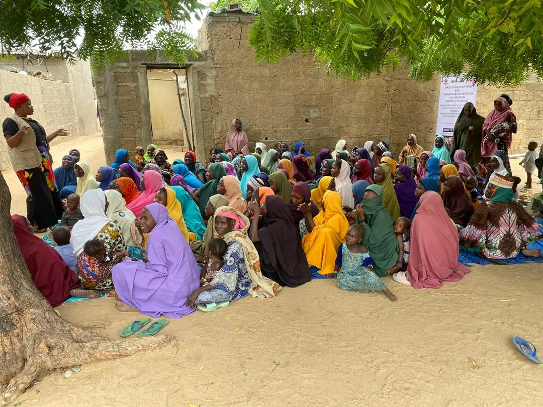 An outdoor community gathering beneath a tree