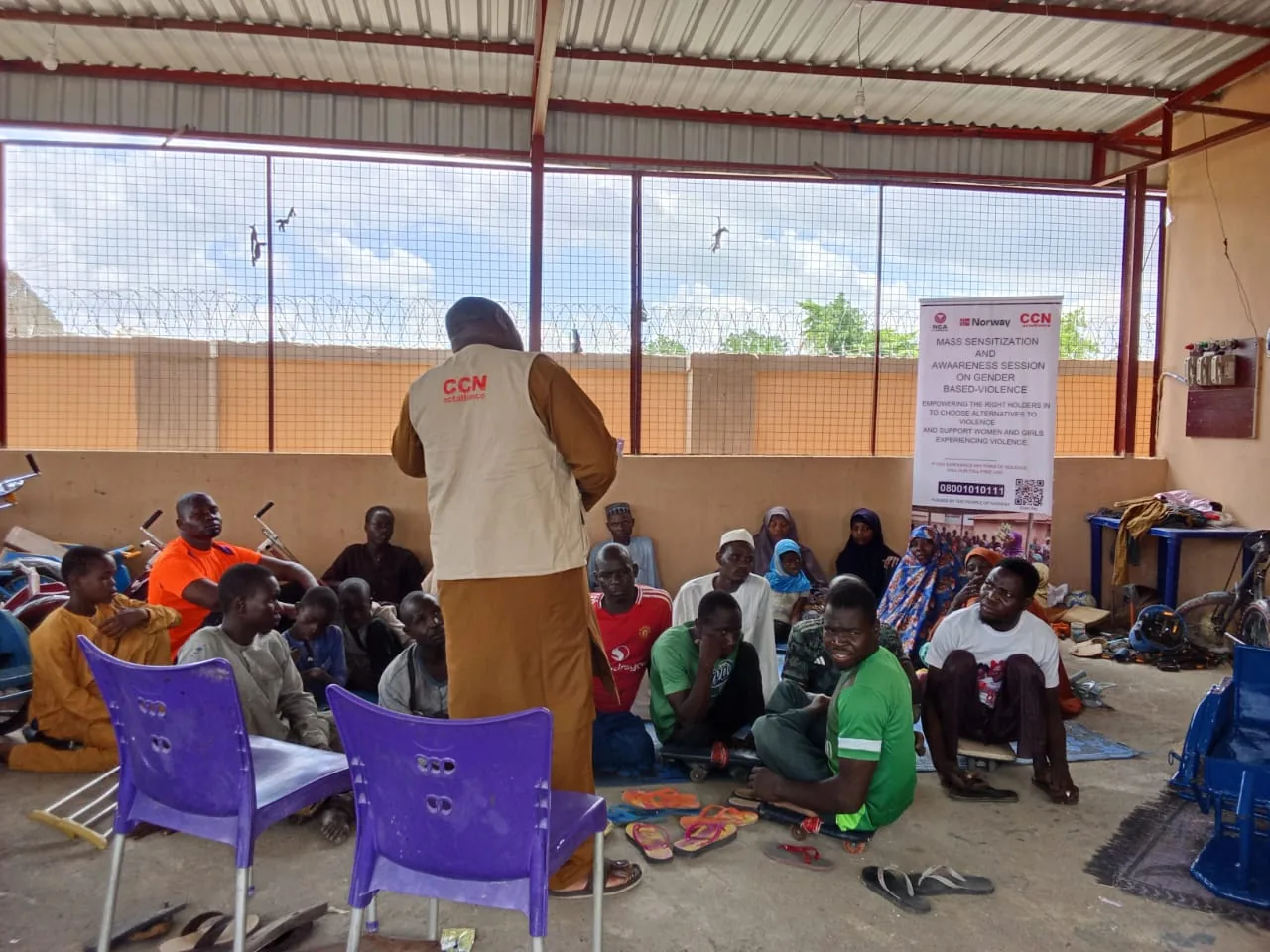 A facilitator speaking to participants in a covered meeting area