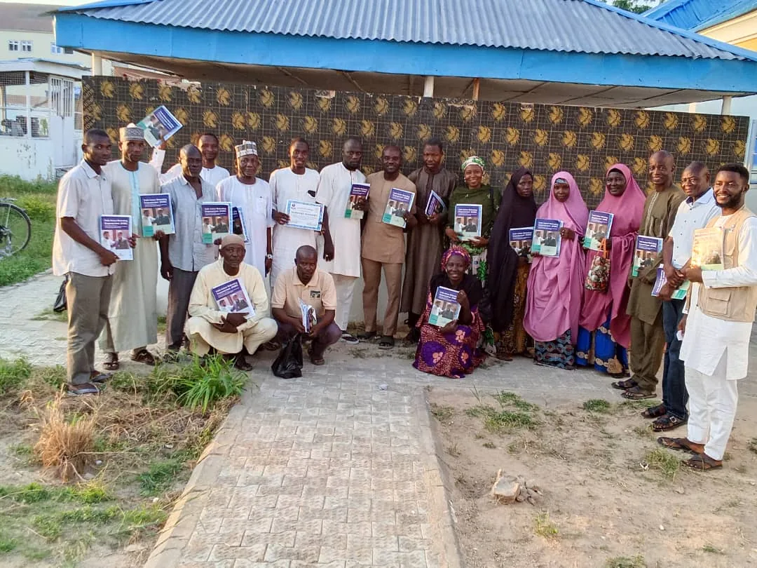 A group standing outdoors with printed materials